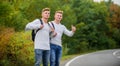 Hitchhiking and stopping car with thumbs up gesture at countryside. On the road. Enjoying summer hike. Looking for Royalty Free Stock Photo