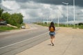 Hitchhiking tourism concept. Travel hitchhiker girl walking on road