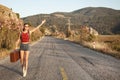 Hitchhiking tourism concept. Travel hitchhiker woman walking on road during holiday travel