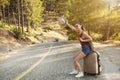 Hitchhiking tourism concept. Travel hitchhiker woman walking on road during holiday travel