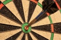 Hitting the bulls eye during a game of darts.