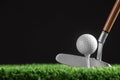 Hitting golf ball with club on artificial grass against black background Royalty Free Stock Photo