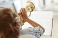 Hitting the high notes. Rearview shot of a little boy playing the trumpet. Royalty Free Stock Photo