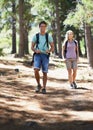 Hitting the trail together. A happy young couple backpacking through the woods.