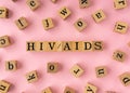 HIV AIDS word on wooden block. Flat lay view on light pink background