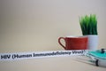 HIV Human Immunodeficiency Virus text, grass pot, coffee cup, syringe, and face green mask.