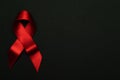 Hiv support. Red ribbon symbol in hiv world day on black background. Awareness aids and cancer. Aging Health month concept Royalty Free Stock Photo