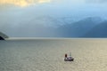 DECEMBER 05. Small fishing vessel inside the fjord of Norway with snow on the mountain