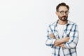 Hmm sounds suspicious. Portrait of unsure and doubtful handsome adult man with beard and moustache in black glasses Royalty Free Stock Photo