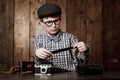 Hmm, these will develop well. Young boy in retro clothing wearing spectacles and checking a photographic negative. Royalty Free Stock Photo