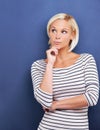 Hmmm...Studio shot of a beautiful young blonde woman looking thoughtful.