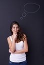 Hmmm, what should I do. Cute young woman standing and thinking with a chalk thought bubble above her head.