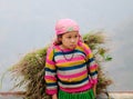 A Hmong girl carrying grass on the rural road at Sapa town, northern Vietnam