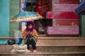 Hmong hill tribe girl sits at market with umbrella Royalty Free Stock Photo