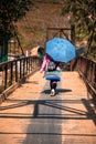 Hmong minority hilltribe woman in traditional costume with umbrella walking away in Lao Cai near Sapa North Vietnam Indochina