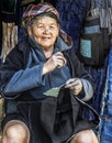 Hmong tribal old woman hand tailoring bags in her shop, Sapa, Vietnam Royalty Free Stock Photo