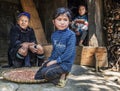 Hmong tribe grandmother resting outside her house with her two grandchildren in a small village, Sapa, Vietnam Royalty Free Stock Photo