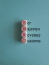 HMRC her majesty revenue and customs symbol. Concept red words HMRC her majesty revenue and customs on cubes