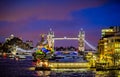 HMS Belfast and Tower Bridge on The River Thames lit up at night in London, UK