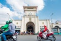 Ho Chi Minh City: the facade of Ben Thanh Market with a group of blonde girls and street traffic blurred in motion