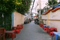Plastic tables and chair along alley of outdoor restaurant at Saigon