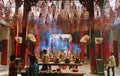 Buddhist believers light incense sticks in pots in chinese temple. Massive fume in temple Royalty Free Stock Photo