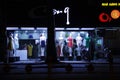 Women dresses displayed on dummies in front of a fashion store. Young Asian saleslady