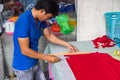 A man mark the fabric to make a traditional ao dai dress