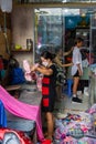 In a small tailor shop in Saigon. A woman irons fabric