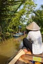 Ho Chi Minh City, Vietnam- November 9, 2022:Woman with conical Vietnamese hat controls a canoe. Tourism rowing boat in the Mekong