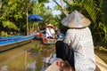 Ho Chi Minh City, Vietnam- November 9, 2022:Woman with conical Vietnamese hat controls a canoe. Tourism rowing boat in the Mekong