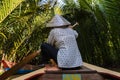 Ho Chi Minh City, Vietnam- November 9, 2022:Woman with conical Vietnamese hat controls a canoe. Tourism rowing boat in the Mekong