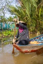 Ho Chi Minh City, Vietnam- November 9, 2022:Woman with conical Vietnamese hat controls a canoe. Tourism rowing boat in the Mekong