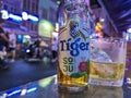 Ho Chi Minh City, Vietnam - Close-up of a cold bottle of Tiger Soju beer with a glass on a table, amidst the lively