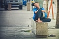 Man barefoot lying on a concrete bench sleeping and relaxing