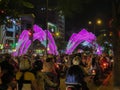 Motorcyclists are at the traffic light at rush hour in the downtown. The city is being decorated illuminated arches