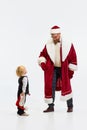 Ho-ho-ho. Merry Christmas. Father, man, looks like Santa Claus having fun with little sweaty kid, sun against white