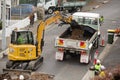 Machinery and workers repairing street surface