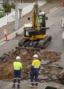 Machinery and workers repairing street surface