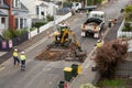 Machinery and workers repairing street surface