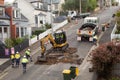 Machinery and workers repairing street surface