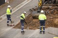 Machinery and workers repairing street surface