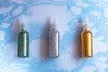 Set of emerald, silver and gold glitters in plastic bottles for soap making on the surface of blue marble, close up, full size, Royalty Free Stock Photo