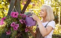 Hobbies at retirement. Happy senior woman watering petunia flowers in pots, gardening in her own garden and smiling Royalty Free Stock Photo