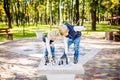 Hobby of Children, Boy and Girl Playing Chess. Funny little brother and sister playing outdoor chess in the park on a public site Royalty Free Stock Photo