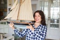 Hobby, collecting, ship and people concept - young woman holding layout of a sailboat Royalty Free Stock Photo