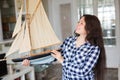 Hobby, collecting, ship and people concept - young woman holding layout of a sailboat Royalty Free Stock Photo