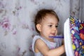Hobby concept. little cute toddler girl enthusiastically draws a pencil in an album. Royalty Free Stock Photo