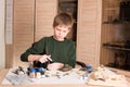 Hobby concept. Teen boy assembling and painting plastic model ta