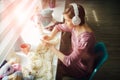 Hobby, mood and liesure concept. Woman relaxing with headphones while knitting tender dress with crochet in sunny day. Female Royalty Free Stock Photo